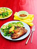 Marinated pork chop with peaches, orange marmalade and side salad