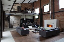 Elegant lounge area and open-plan kitchen in loft apartment with brick and stone walls