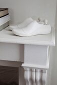 Shoe lasts painted white decorating mantelpiece