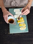 Halloumi being brushed with flavoured oil