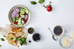 A bread crisp salad with cucumber, tomatoes, olives and capers being made