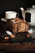 Banana, chocolate and pecan nut bread in front of a teapot and a tea cup
