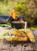 Grilled corn cobs with various accompaniments