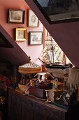 Collectors' items on carved trunk below narrow dormer window