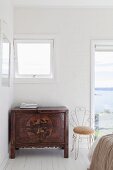 Antique ethnic cabinet and filigree metal chair in front of window door