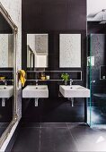 Two square sinks in modern bathroom with mirror on antique frame to one side