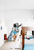 Child wearing elephant mask climbing loft-bed ladder