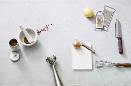 Various kitchen utensils, a lemon, an onion and spices