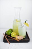 Ginger and lime soda with ingredients on a varnished tray
