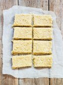 Vegan coconut slices on a piece of baking paper (seen from above)