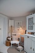 White dresser next to cosy seating area with romantic ambiance