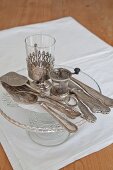 Vintage Silber Besteck auf Kuchenständer und weisses Platzset