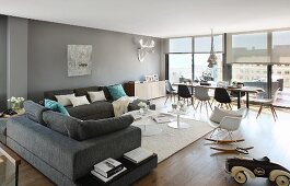Corner sofa and dining set with classic Eames chairs in spacious penthouse interior