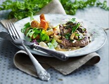 Beef steak with a mushroom sauce and root vegetables