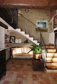 Tiled foyer with bench next to staircase in traditional, Spanish stone house