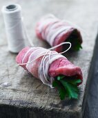 Raw beef roulade wrapped in bacon and filled with parsley