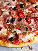 Pizza with salami, Parma ham and smoked ham