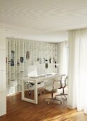 In weissen Wohnraum integrierte Arbeitsnische mit Schreibtisch und Aluminium Chairs vor Einbauregal