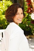 A brunette woman wearing a white blouse