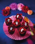 Chocolate cupcakes decorated with red roses and skulls (Mexico)