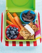 Müsliriegel, Heidelbeeren und Möhren in Lunchbox