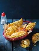Baked puff pastry parcels with a snoek-potato filling in a bread basket served with sweet chilli sauce