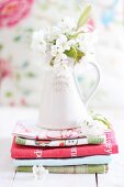 Cherry blossom in ceramic vase on stacked tea towels