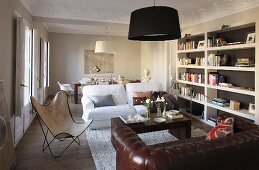 Seating area with leather sofa and Butterfly easy chair in front of dining area