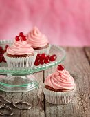 Cupcakes mit rosa Buttercreme und roten Johannisbeeren