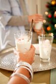 A woman holding a glass of Christmas dessert