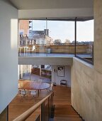 Blick durch Glasfassade auf Terrasse über offenem Wohnraum mit Essplatz in Luxuswohnung