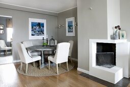 Elegant dining room in pale grey with open fireplace and dining set