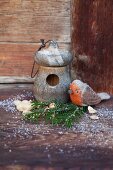 Hand-crafted felt robin next to nesting box