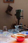 Colourful glass bowls and vintage bench drill on table