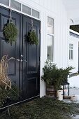 Advent arrangement of fir branches on veranda of Scandinavian house