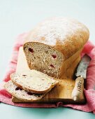 Sliced cranberry and walnut bread on a chopping board