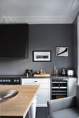 Kitchen with rustic dining table and kitchen counter against dark grey wall