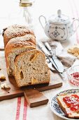 Challah with sesame seeds, sliced, on a chopping board