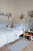 Pale blue walls and shabby-chic bed in boy's bedroom