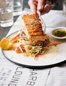 Grilled salmon fillet with coleslaw and pesto in a diner