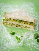 A double-decker sandwich with avocado and bean sprouts