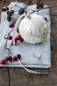 A Christmas tree bauble and hawthorn berries