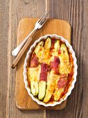 Gratinated courgette with ham and cheese in tomato sauce