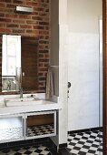 Washstand and mirrored cabinet on exposed brick wall and chequered floor in bathroom