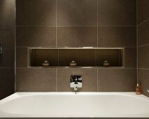 Braun gefliestes Badezimmer mit Ablagenische über der Badewanne