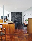 Free-standing sideboard, hunting trophy, lounge area and dining area in front of fireplace with grey-tiled chimney breast