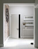 Foyer with open door and console table below drawings in white frames