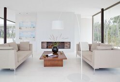 Designer-Loungebereich mit offenem Kamin, weißem Boden und raumhohen Verglasungen