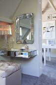 Floating dressing table mounted on wall below mirror with curving silver frame