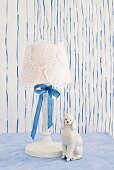 White table lamp with doilies and silk ribbon decorating lampshade